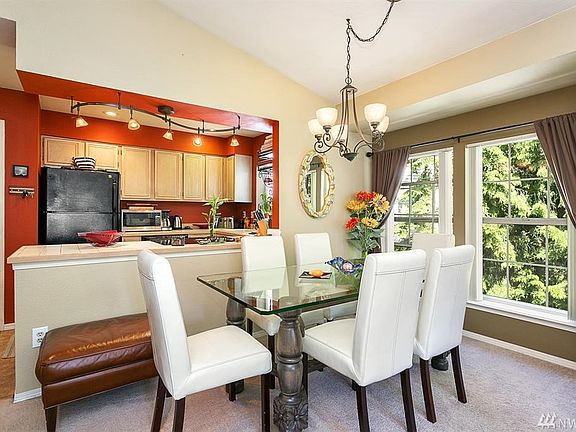 Spacious living room with cozy wood burning fireplace and tall vaulted ceilings.  Entrance to the balcony from here.