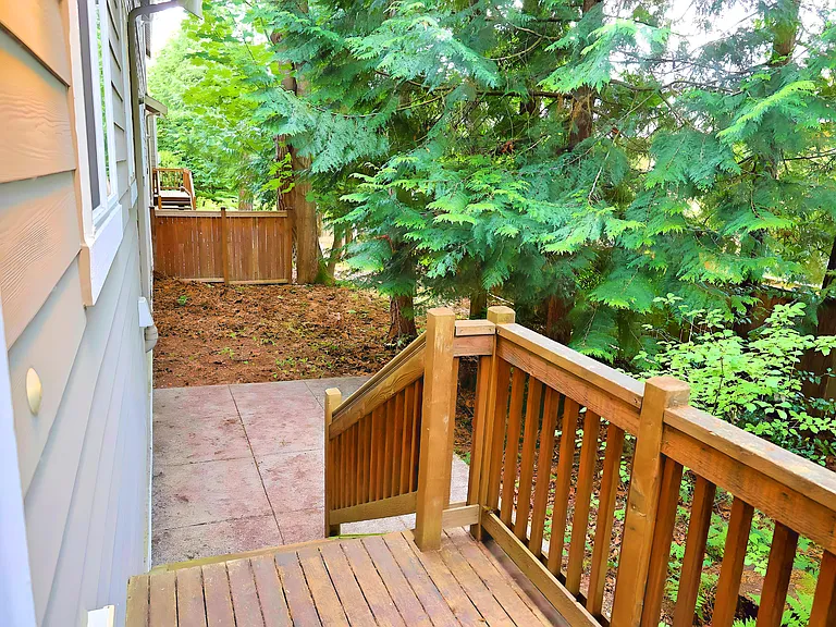 Small deck and backyard, surrounded by trees, providing a private and quite environment