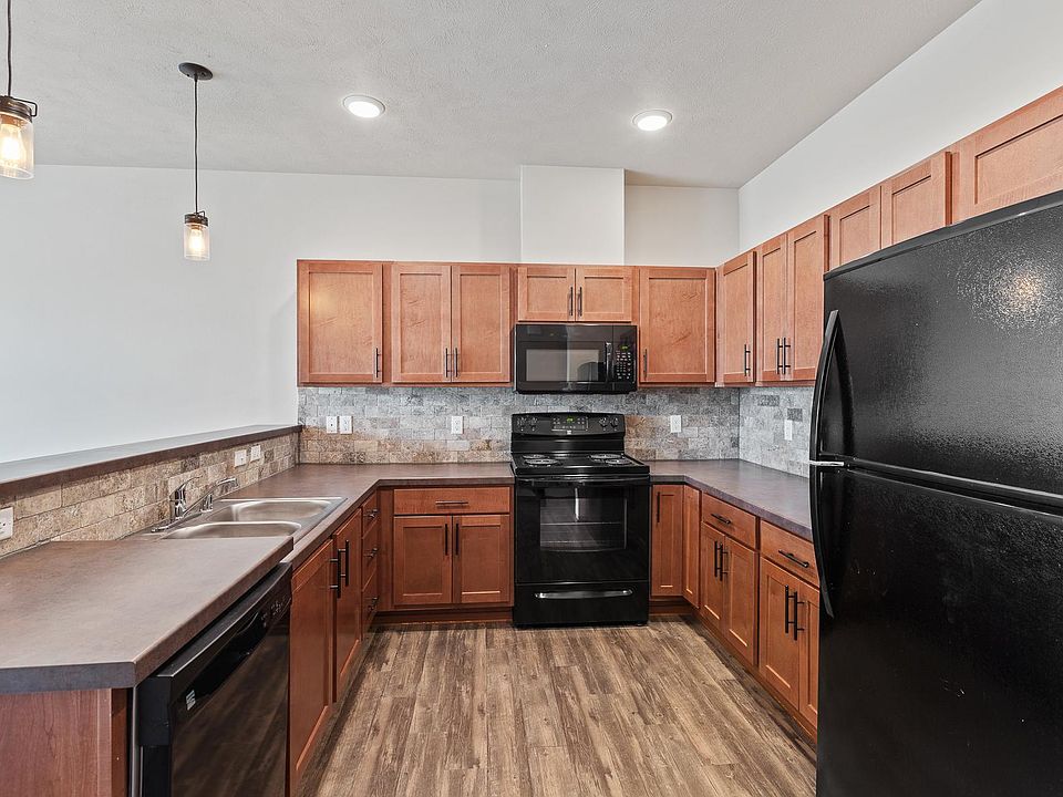 Edison bulbs, full tile backsplash, black appliances, and plenty of counter and storage space.