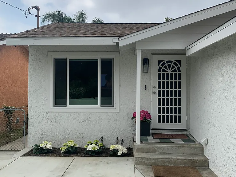 Inviting front exterior featuring a covered porch, and well-maintained stucco exterior.