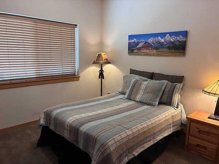 Guest bedroom with full-sized bed and nightstand.