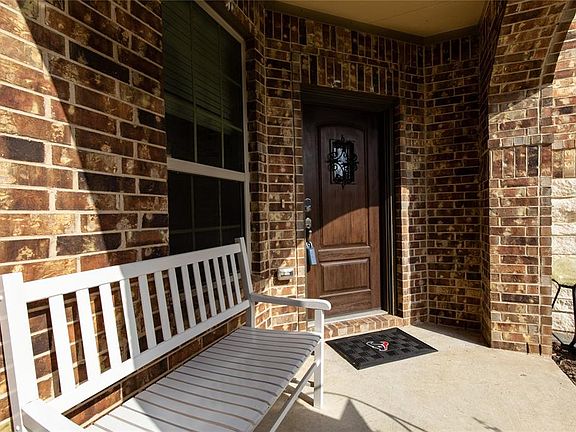 This charming front porch provides a covered entry as you head to the wood front door with wrought-iron accents.