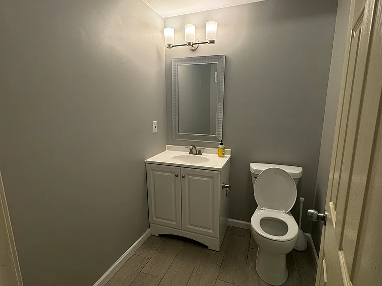 Finished basement bathroom featuring modern tile flooring, updated vanity, and standing shower.
