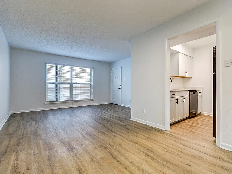 A bright living room with vinyl floor is shown at ReNew on Cantrell.