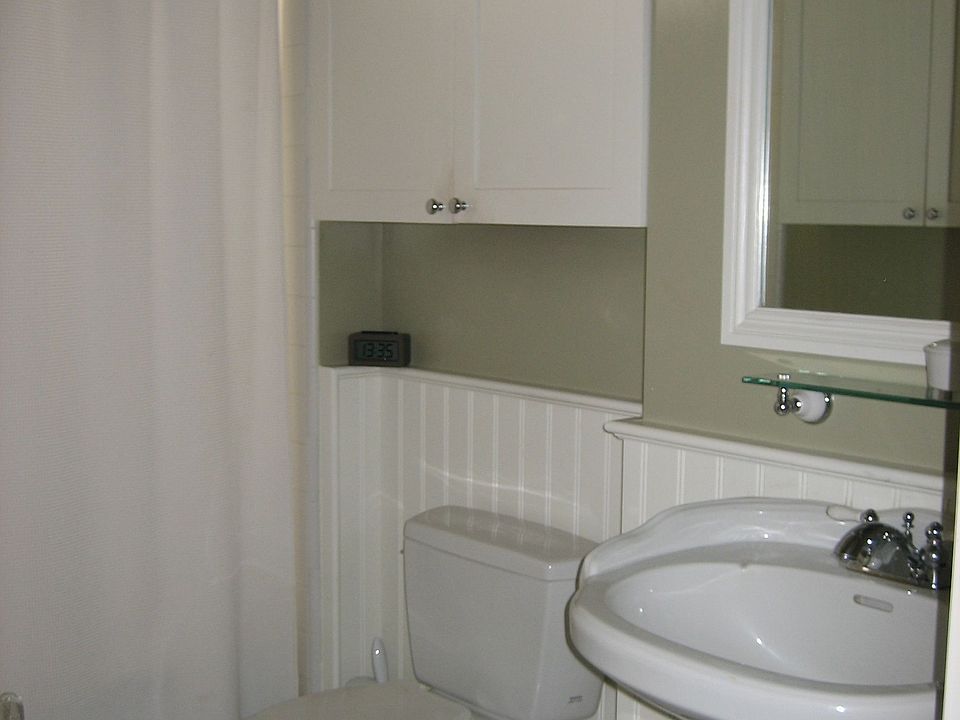 Main bathroom with marble flooring, wainscot paneling, much storage