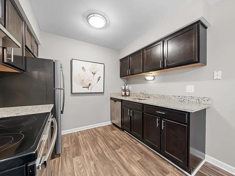 Spacious Kitchen with stainless steel appliances and dark cabinets at Lakeside Village Apartments Clinton Township, MI