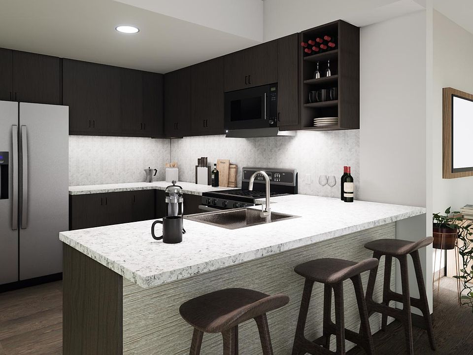 Light, bright and spacious kitchen with granite countertops, gourmet stainless steel appliances, and a breakfast bar