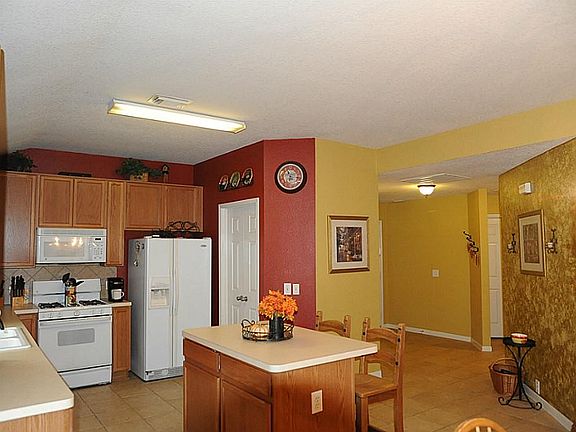 Kitchen area features an island, microwave and access to utility room.
