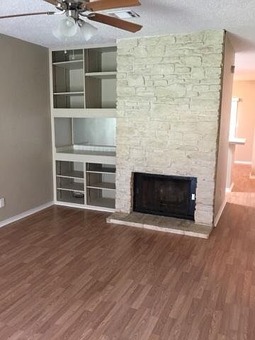Den with very nice fire place with white Austin stone