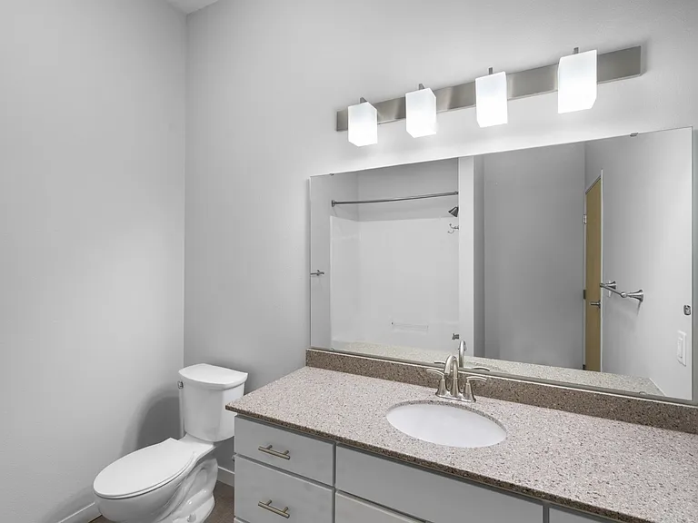 Modern bathroom with elegant vanity, sleek lighting, and spacious mirror offering a bright and inviting atmosphere. Modern bathroom with elegant vanity, sleek lighting, and spacious mirror offering a bright and inviting atmosphere.