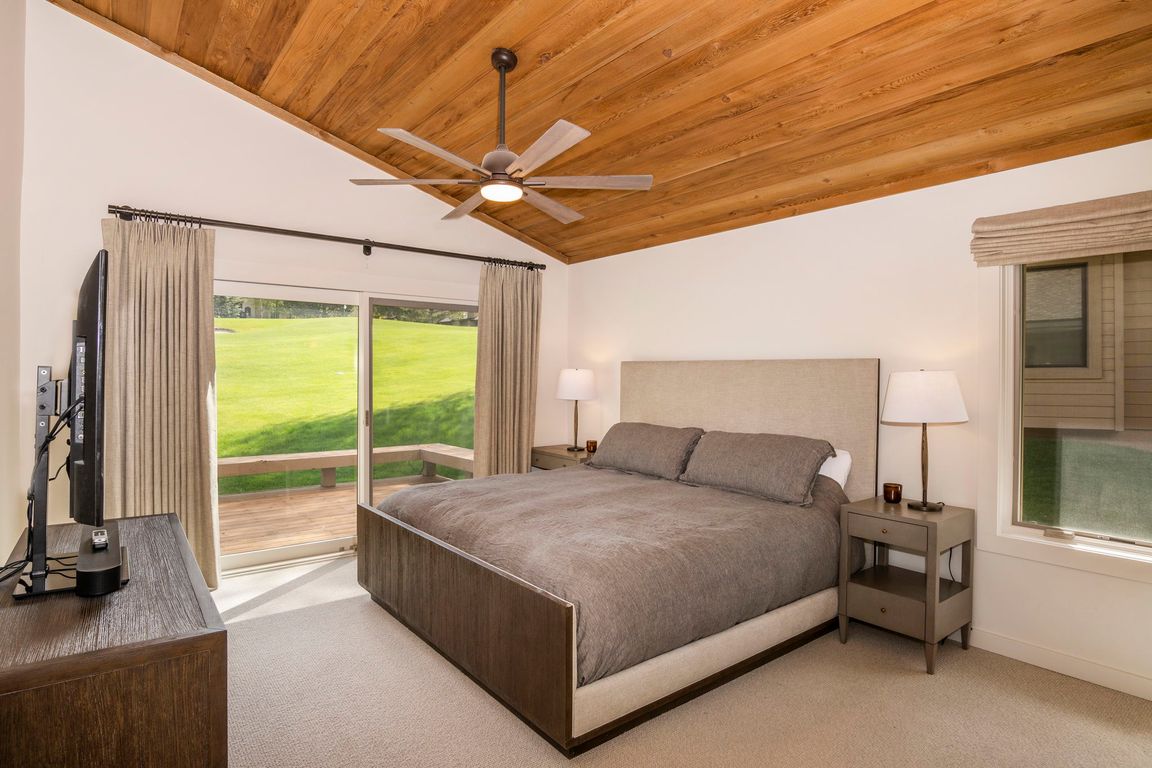 Primary bedroom with deck and view of golf course