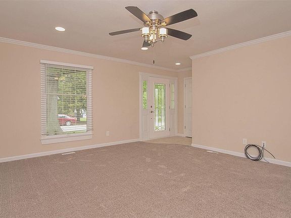 Living room -- new carpet & paint (it's really a beige -- not pink); new ceiling fan; new can lights; new leaded glass front door with sidelights.