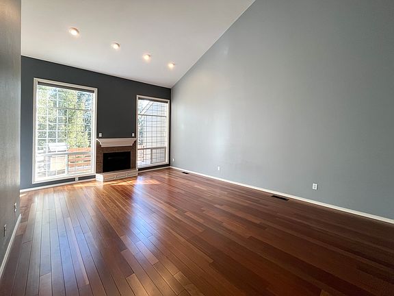 Living room has a gas fireplace and stunning treetop views.