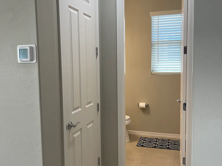 Half bath doorway off of living area hall. Coat & vaccum closet to the left.