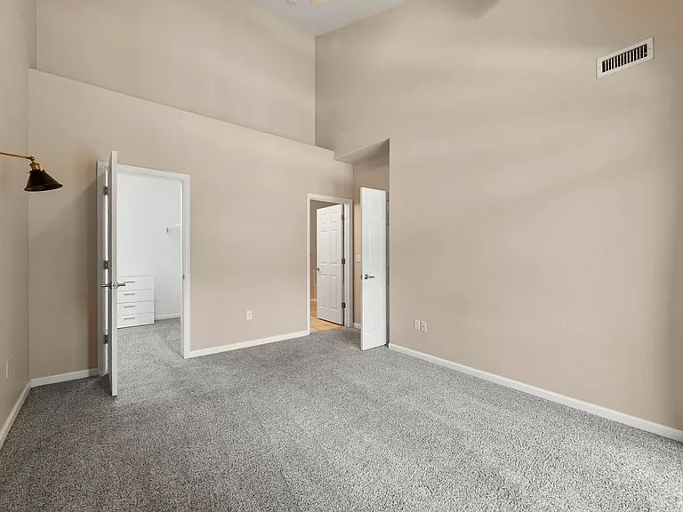Spacious Primary Bedroom: Vaulted ceilings, private balcony (with storage), walk-in closet, en-suite bath adjoins.