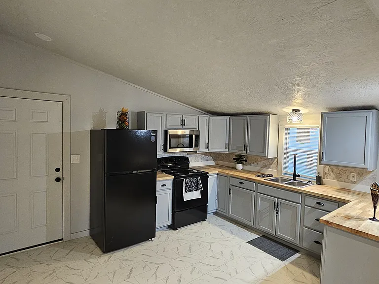 Modern kitchen design featuring new range, microwave, refrigerator and updated lighting