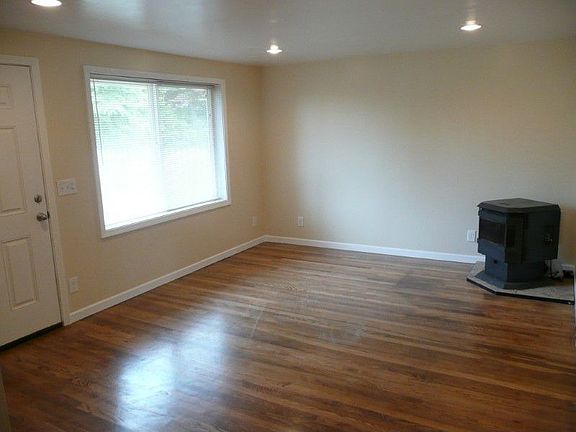 Living room has newly refinished hardwood floors, large picture window and a pellet stove for cold n