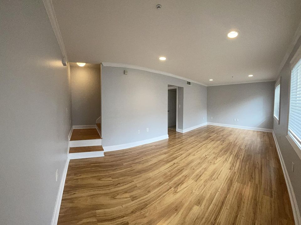 Cozy living room in a charming Symra townhome. This inviting space offers ample natural light and comfortable seating arrangements. Entertain guests in style. Ideal for relaxation or hosting gatherings in this gem of a home.