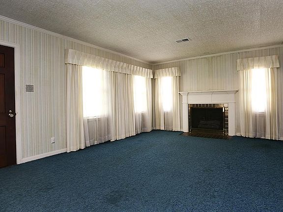 Spacious living room with classic mantel. Carpet has protected hardwoods for 40 years. "cannot remem