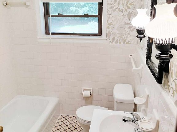 Original bathroom with tub and large linen closet