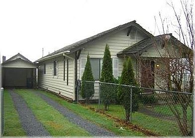 Driveway leads to detached garage/shop and covered parking.