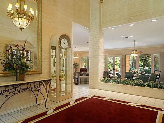 Guests enter the home into the elegant 2-story Foyer that is graced with a massive chandelier, vertical columns the pull the eye upwards, and yet dramatic views that draw attention inward