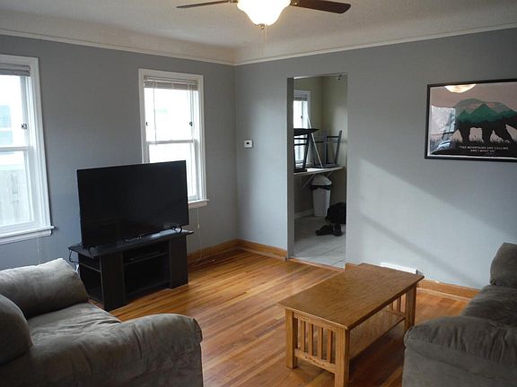 Living room with hardwood floors, new paint, and new ceiling fan!
