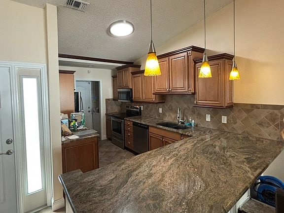 Beautiful kitchen stainless appliances and washer and dryer off kitchen area with pocket door