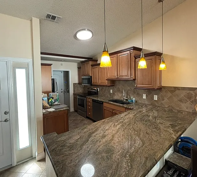 Beautiful kitchen stainless appliances and washer and dryer off kitchen area with pocket door