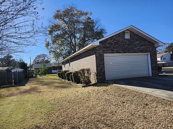 View of the left side of the house. Nicely manicured boxwood shrubs and lawn.