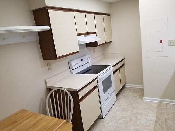 Eat-In Kitchen with appliances (fridge, stove, range hood, dishwasher), vinyl floor, fresh paint, double sink.