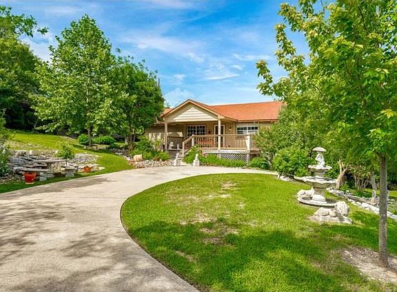 Long, circular driveway with home nestled on second lot.