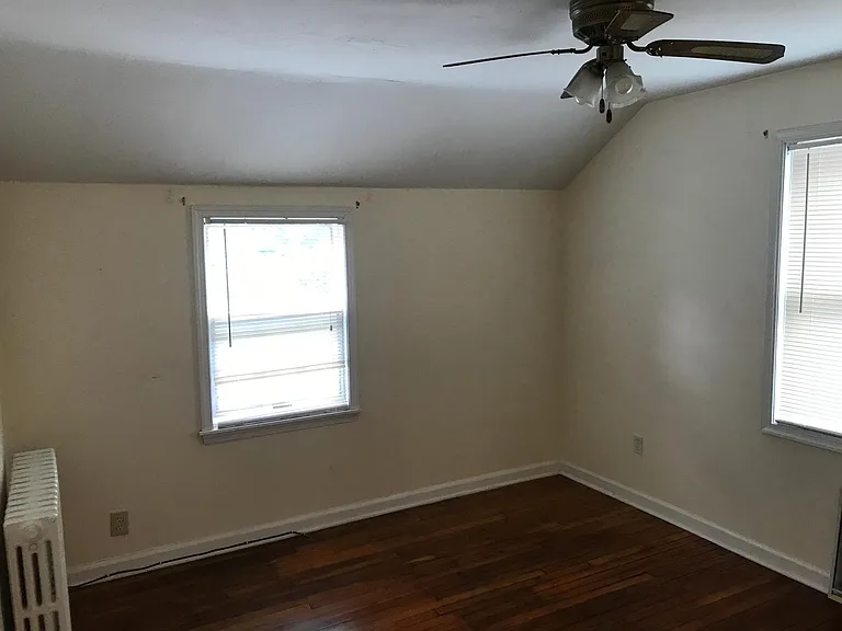 Bedroom w/ closet and door separating from living room and kitchen area.