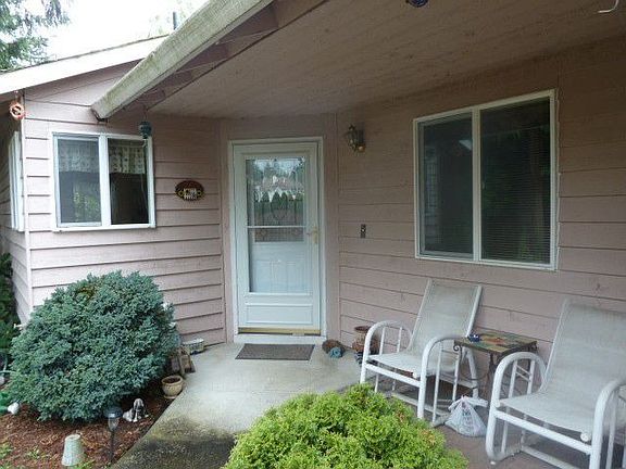 Charming front porch entry beyond the gated arbor