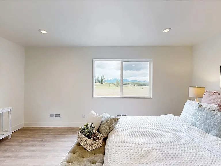 The upstairs suite offers breathtaking mountain views, a luxurious en-suite bath with high-end finishes, and a spacious walk-in closet. Staged Photo.