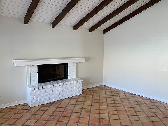 LIving room w/ beam ceiling and decorative fireplace