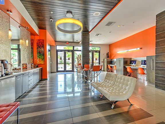 Interior image of the resident lounge area with seating, a coffee bar, and computer stations.