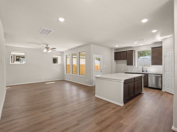 An additional view of the open concept living space filled with large windows allowing natural light
