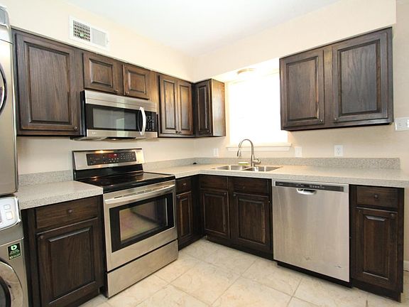 The kitchen is all-new with stainless steel appliances, quar