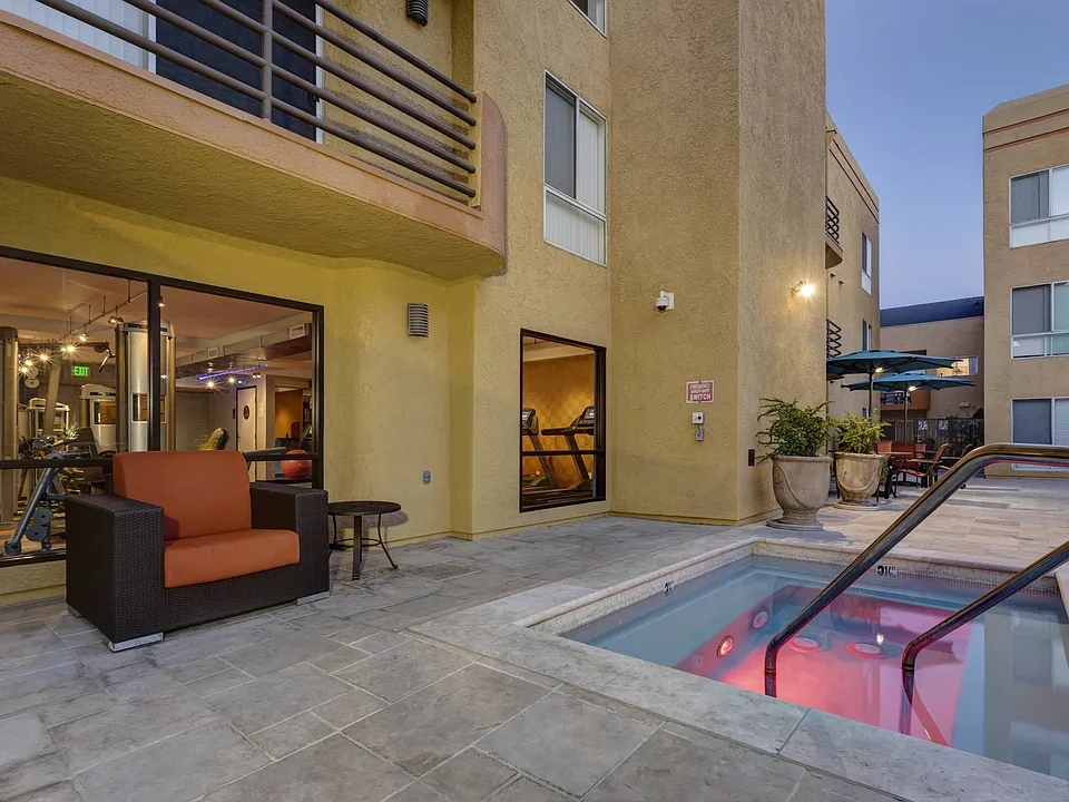 Apartments in Burbank, CA - Jacuzzi and Patio Area with Seating Lit Up at Night