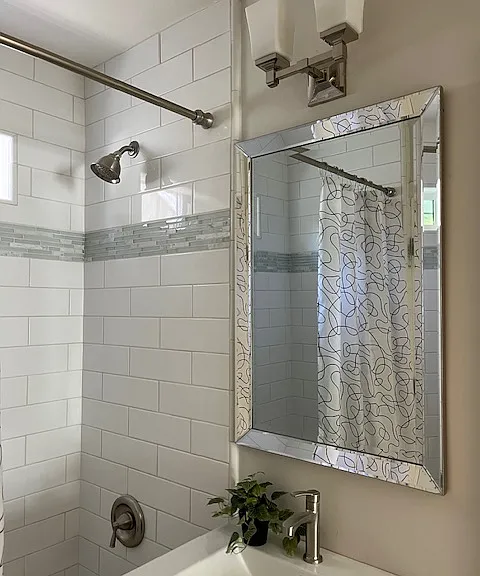 Beautiful newly remodeled bathrooms with bath/shower combination with white subway tile surround and marble/glass/tile accents. Grey shaker cabinet with integrated porcelain sink, restoration hardware lighting, tile floors and a window for natural light.