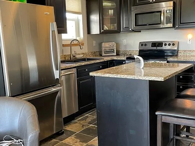 Range, microwave, coffee maker, toaster oven/air fryer, fridge with freezer.