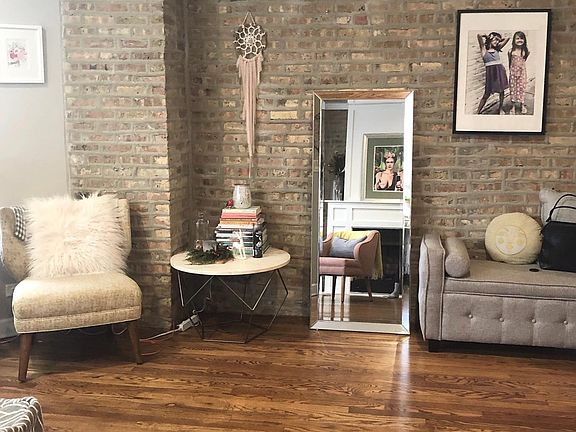 Another view of living room showcasing brick accent wall