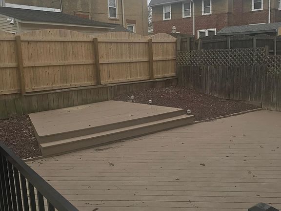 Fenced in backyard with deck
