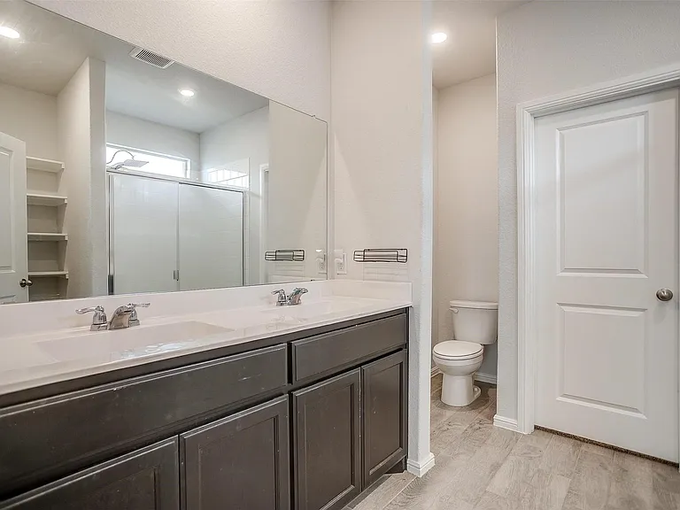 Primary bath with dual sinks and walk-in shower.