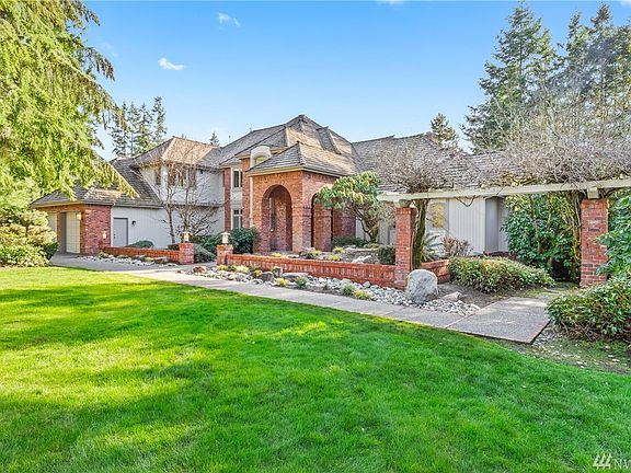 Wisteria arbors, extensive brick work, a pond and rockery waterfall grace the front entry.