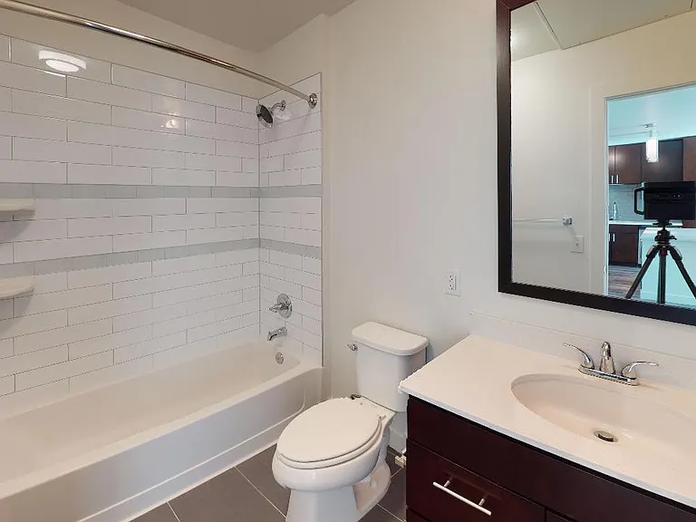 Apartment bathroom with tile flooring.