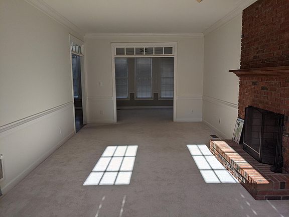Living room with wood burning fireplace and den/office