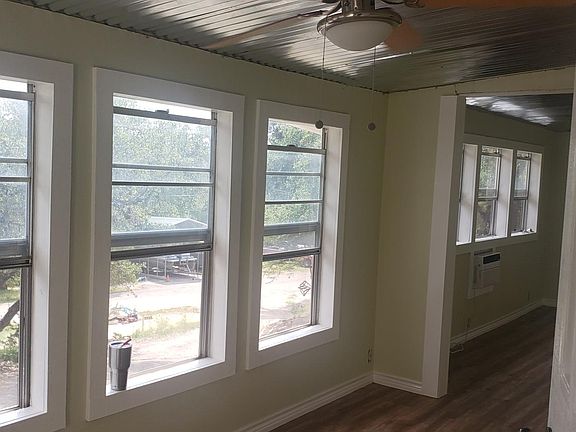 Trees all around house. Porch room with wall of windows.