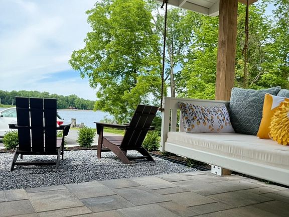 Daybed swing under a covered porch with a celing fan
